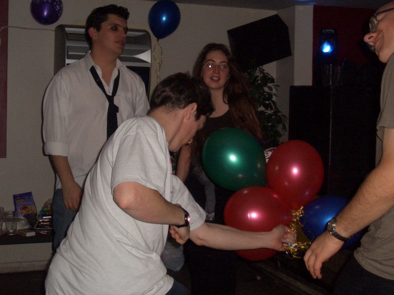 Mike, Becky and Matthew waving a bunch of balloons on the dancefloor