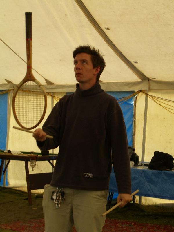 Charlie balancing a squash racquet on a handstick